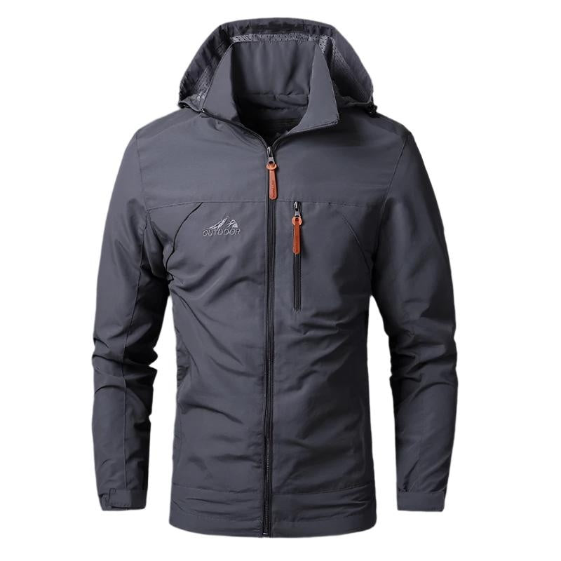 Grijze outdoorjas met capuchon en ritszak, gedragen door model | Boutique Moda