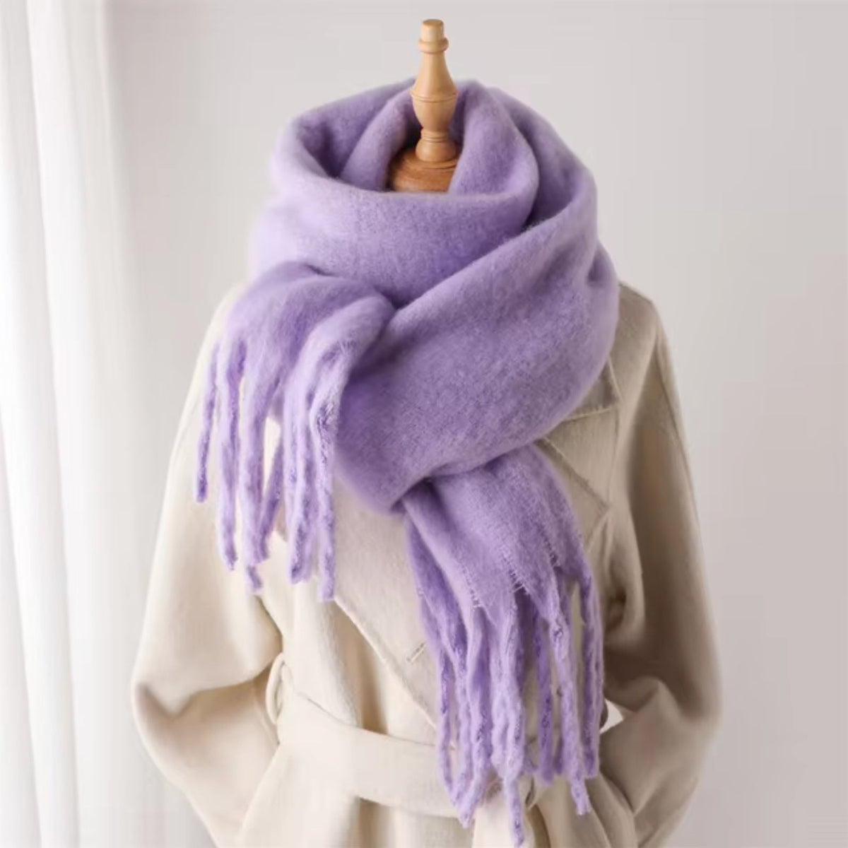 Lila wintersjaal met franjes, gedragen door paspop over beige jas | Boutique Moda