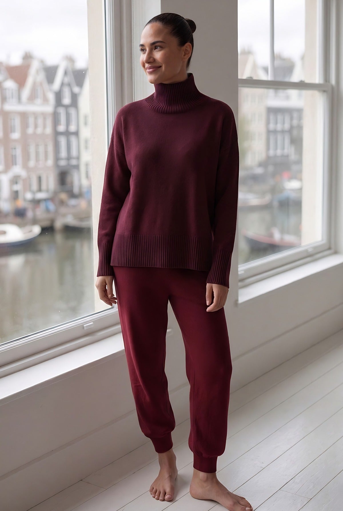 Vrouw in een gebreid huispak met coltrui in een Amsterdams appartement
