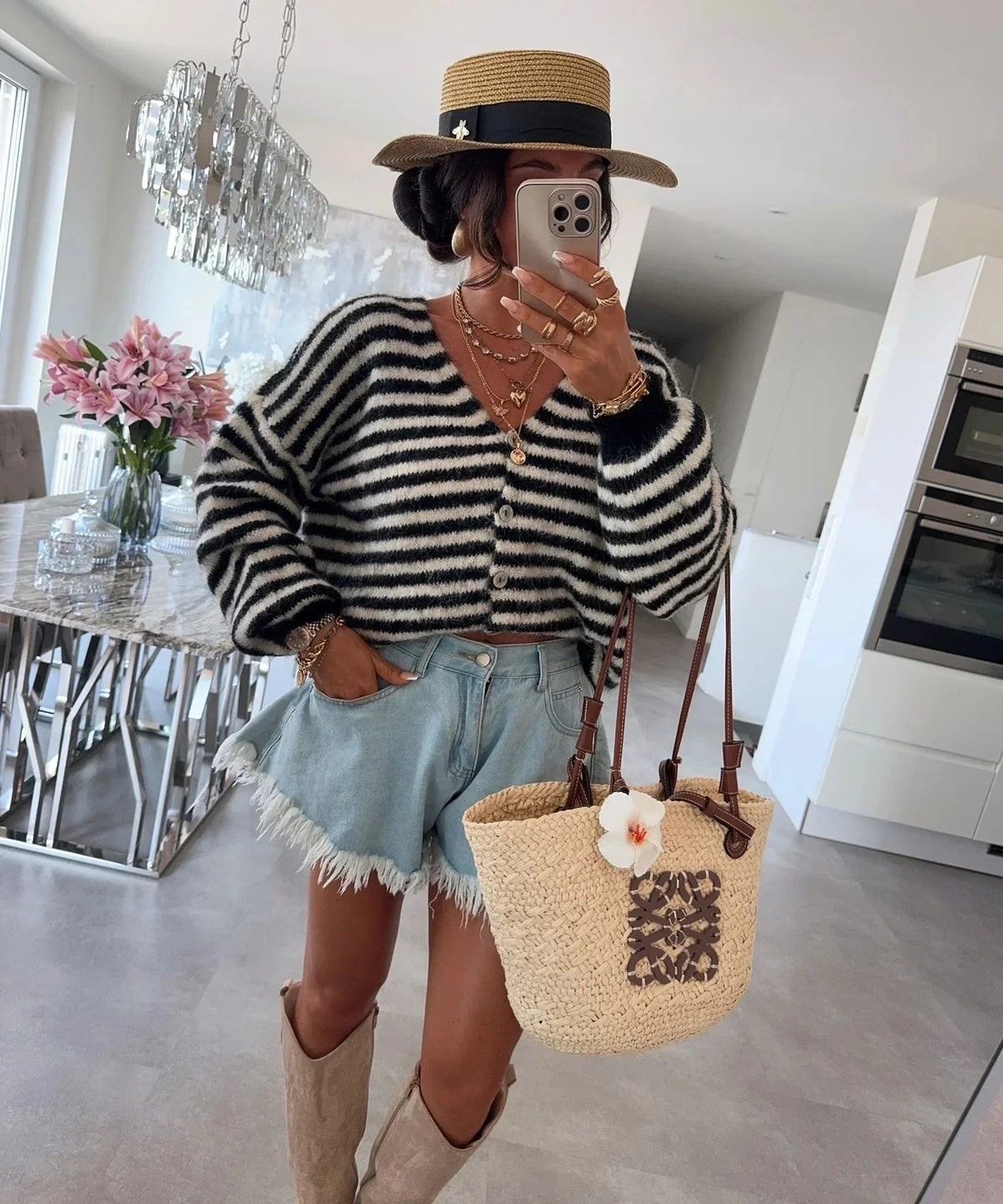 Zwart-wit gestreept oversized vest gestyled met een rieten tas