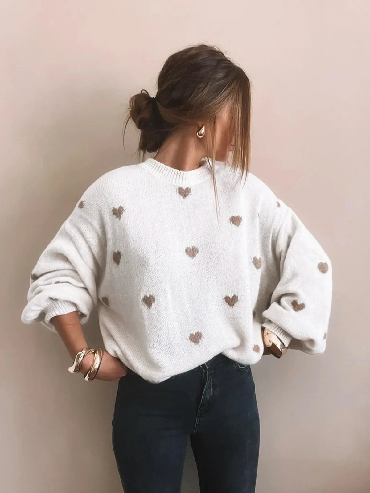 Witte oversized hartjestrui met beige hartjes, handen op de heupen