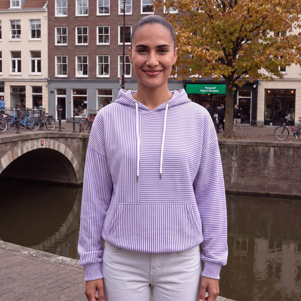 Vrouw draagt de lila gestreepte trui met capuchon bij een gracht in Amsterdam | Boutique Moda