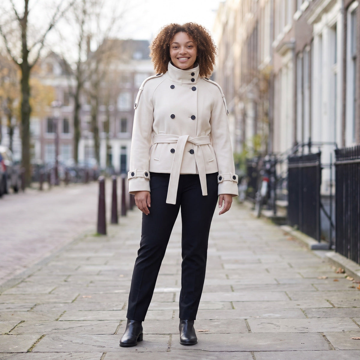 Crèmekleurige korte capejas met opstaande kraag, gedragen door vrouw op straat | Boutique Moda