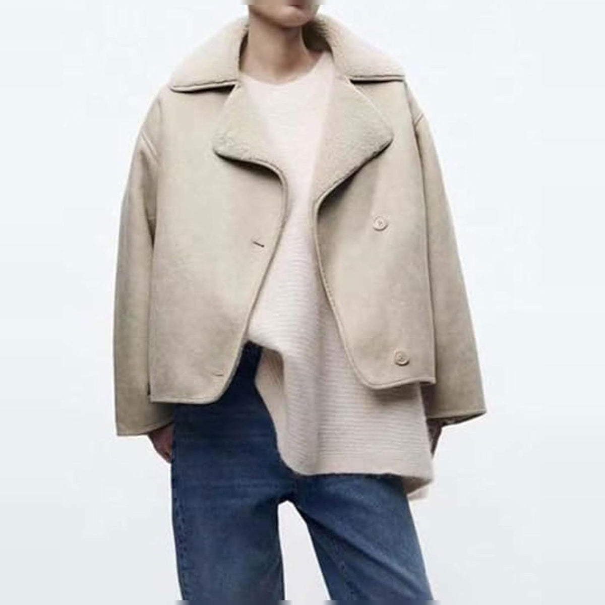 Beige lammy coat met open voorkant en zichtbare crèmekleurige teddyvoering, gedragen door vrouw | Boutique Moda