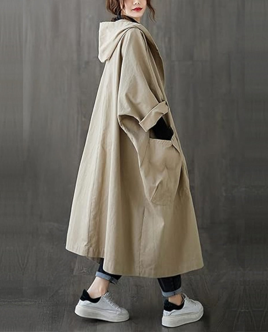 Beige lange oversized regenjas met capuchon, gedragen door vrouw buiten | Boutique Moda