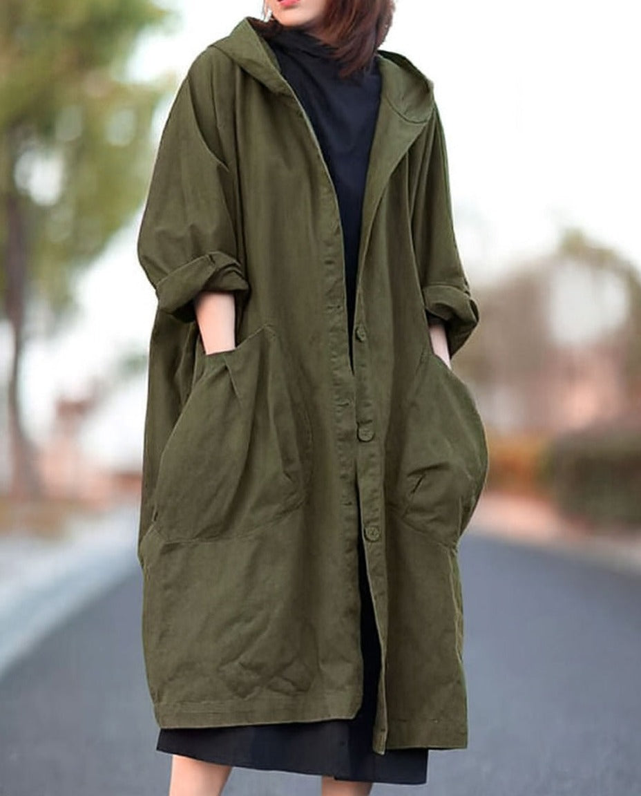 Legergroene lange oversized jas met capuchon, gedragen door vrouw buiten | Boutique Moda