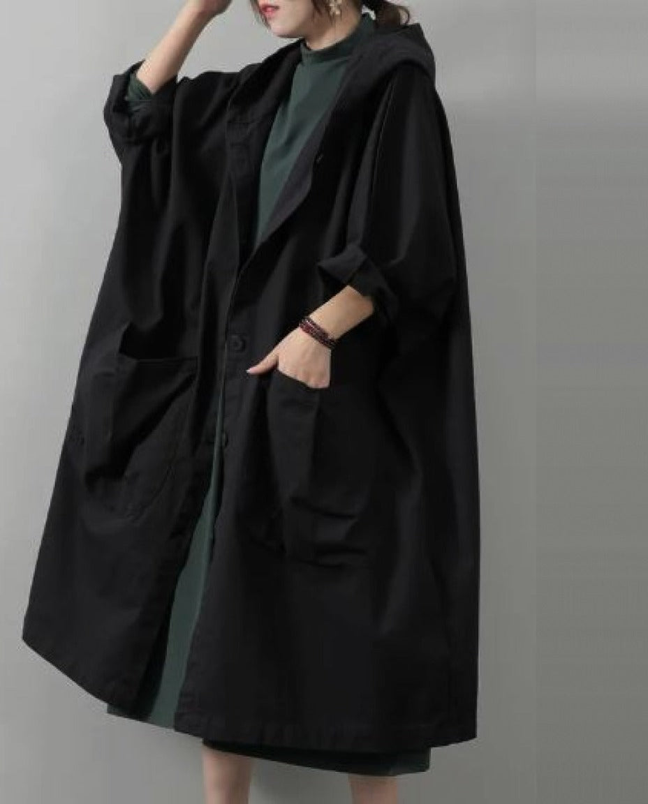 Zwarte oversized regenjas met capuchon en zakken, gedragen door vrouw | Boutique Moda