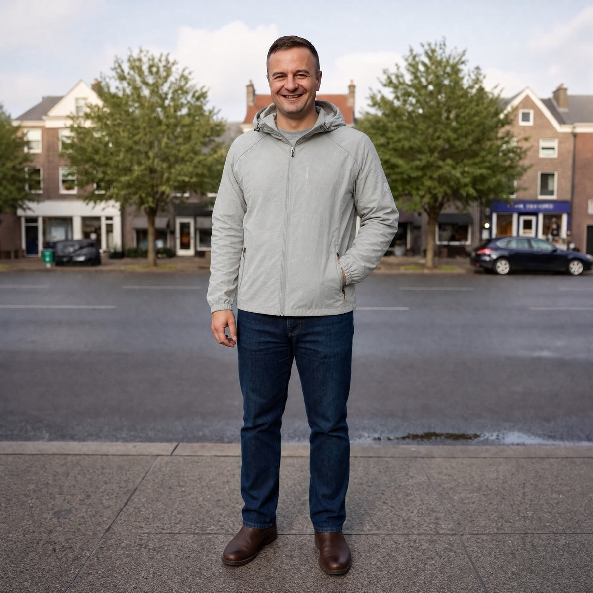 Grijze outdoorjas met capuchon, gedragen door man op straat | Boutique Moda