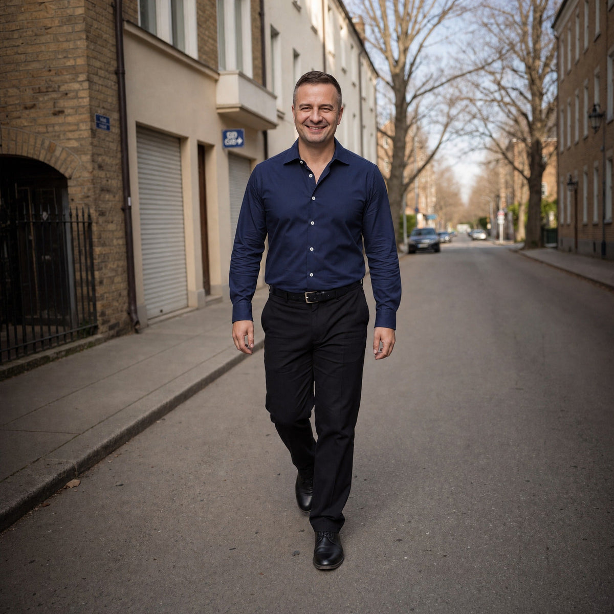 Man draagt donkerblauw overhemd met lange mouwen en zwarte broek op straat | Boutique Moda