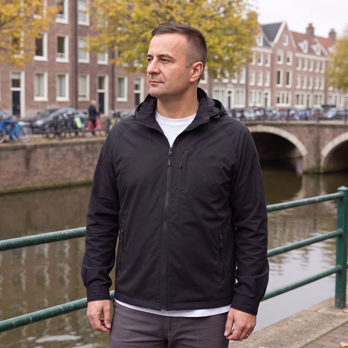 Man draagt de zwarte regenjas met capuchon