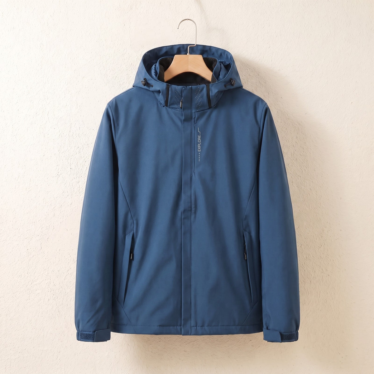 Blauwe waterdichte jas met capuchon aan een hanger