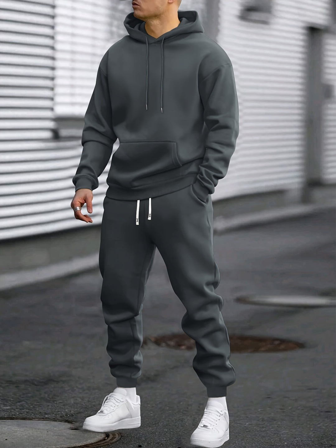 Man in een donkergrijs joggingpak met hoodie en joggingbroek | Boutique Moda