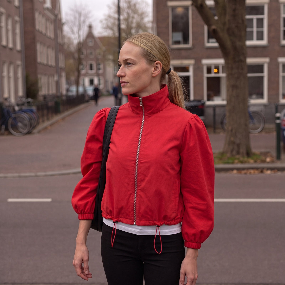 Vrouw in het rode korte jasje op een Amsterdamse straat | Boutique Moda