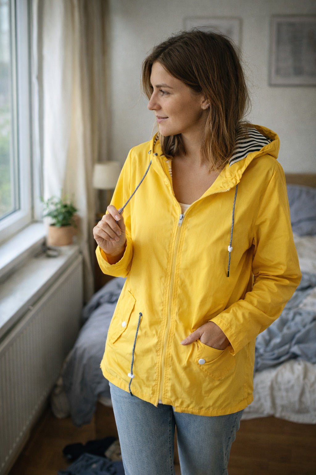 Gele regenjas bij het raam, capuchon met gestreepte voering | Boutique Moda