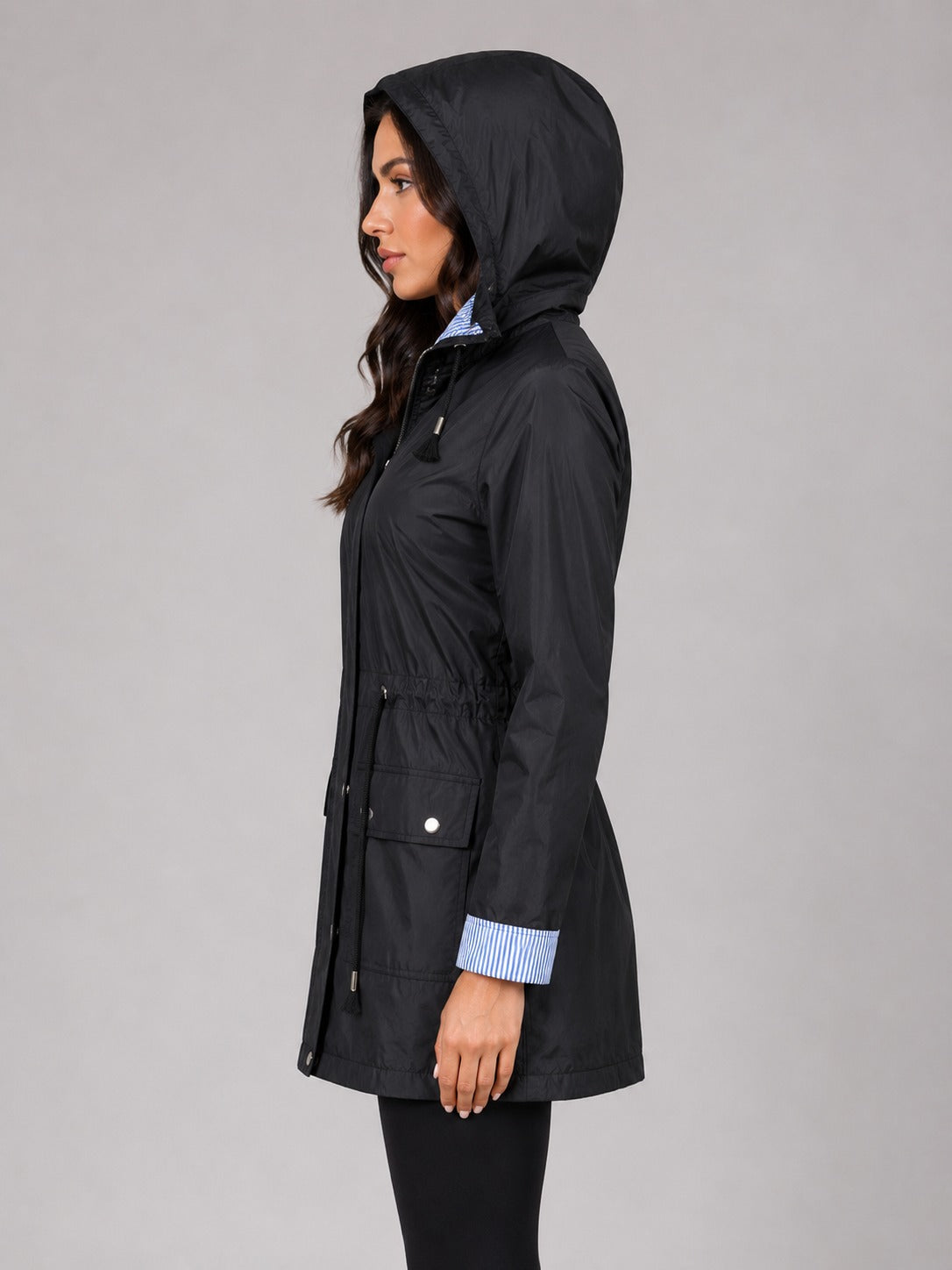 Zijkant van de zwarte regenjas met de capuchon op | Boutique Moda