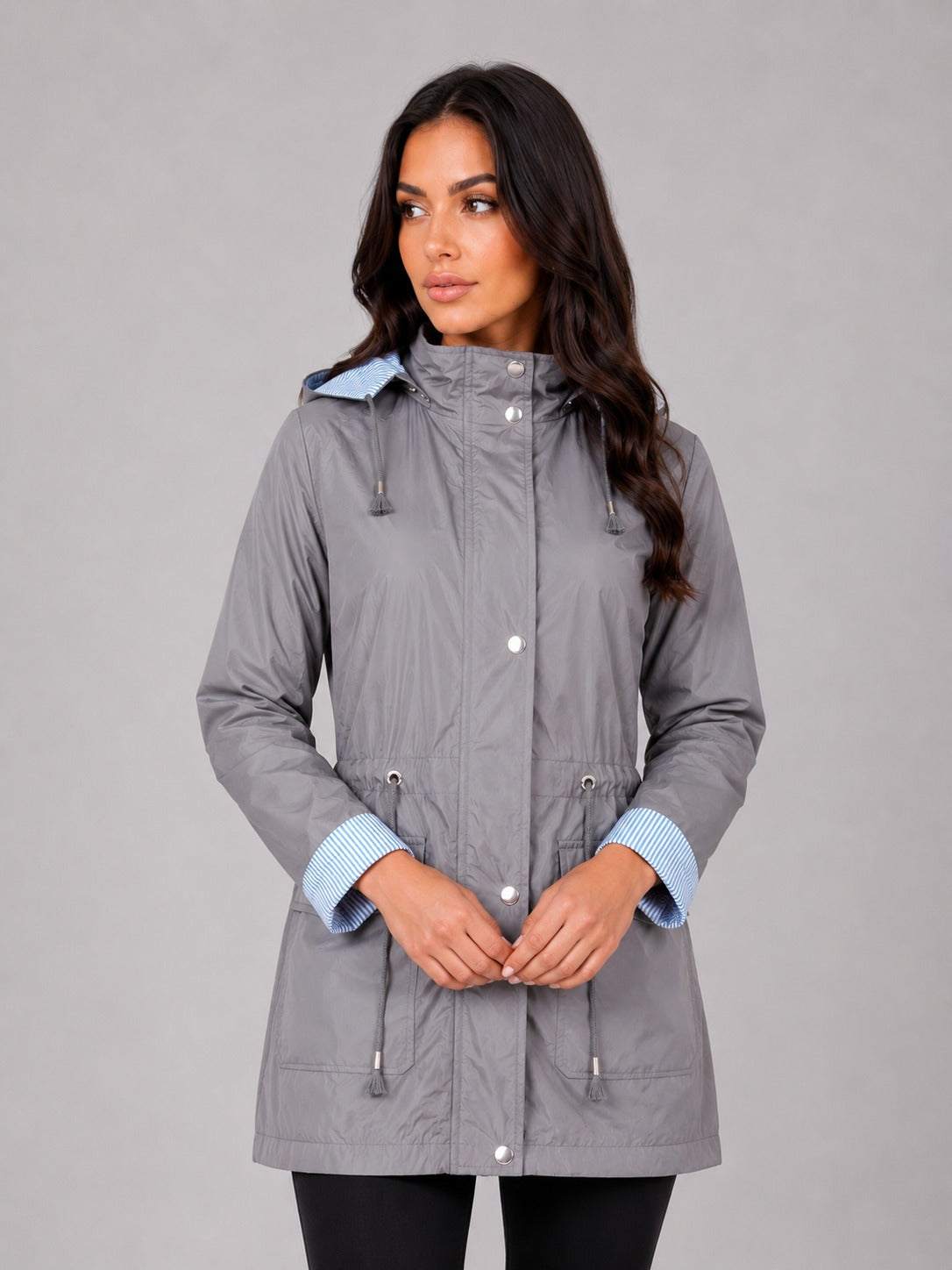 Grijze regenjas met capuchon, taillekoord en gestreepte manchetten | Boutique Moda