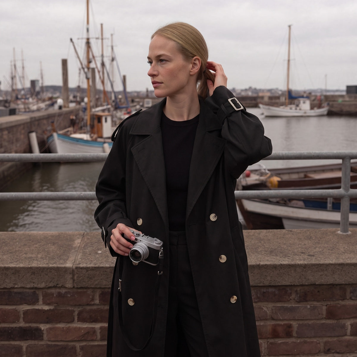 Lange trenchcoat in zwart met ceintuur, buiten gedragen | Boutique Moda