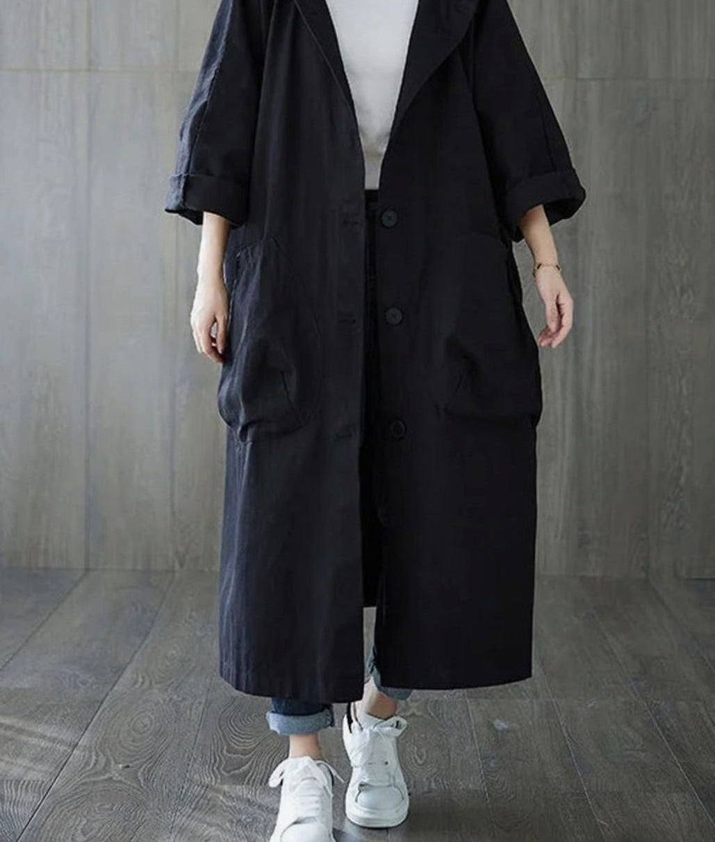 Zwarte oversized jas met capuchon over een wit shirt | Boutique Moda