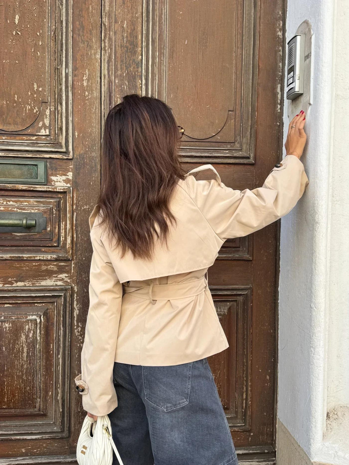 Achterkant van de beige korte trenchcoat | Boutique Moda