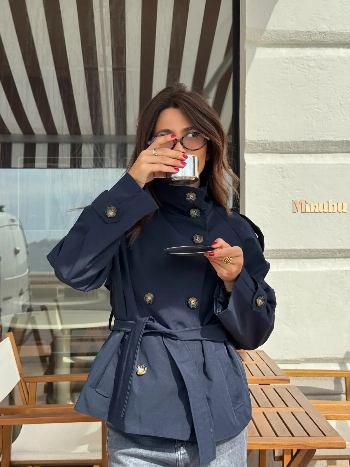 Marineblauwe korte trenchcoat op een terras | Boutique Moda