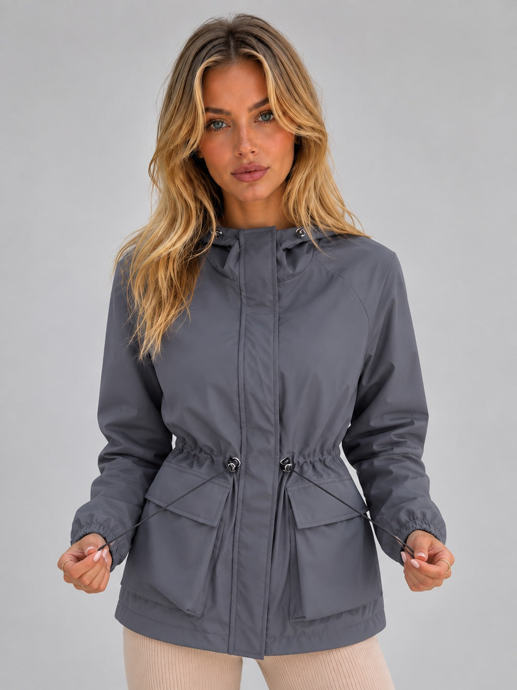 Grijze korte regenjas met capuchon, taillekoord en klepzakken | Boutique Moda
