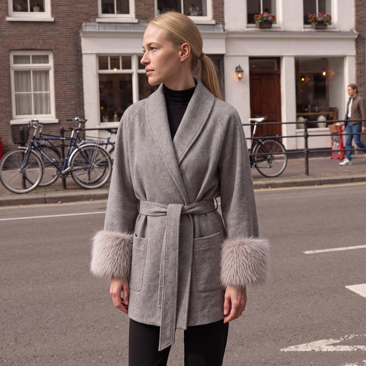 Vrouw in de grijze wikkeljas met nepbont manchetten in een Nederlandse straat | Boutique Moda