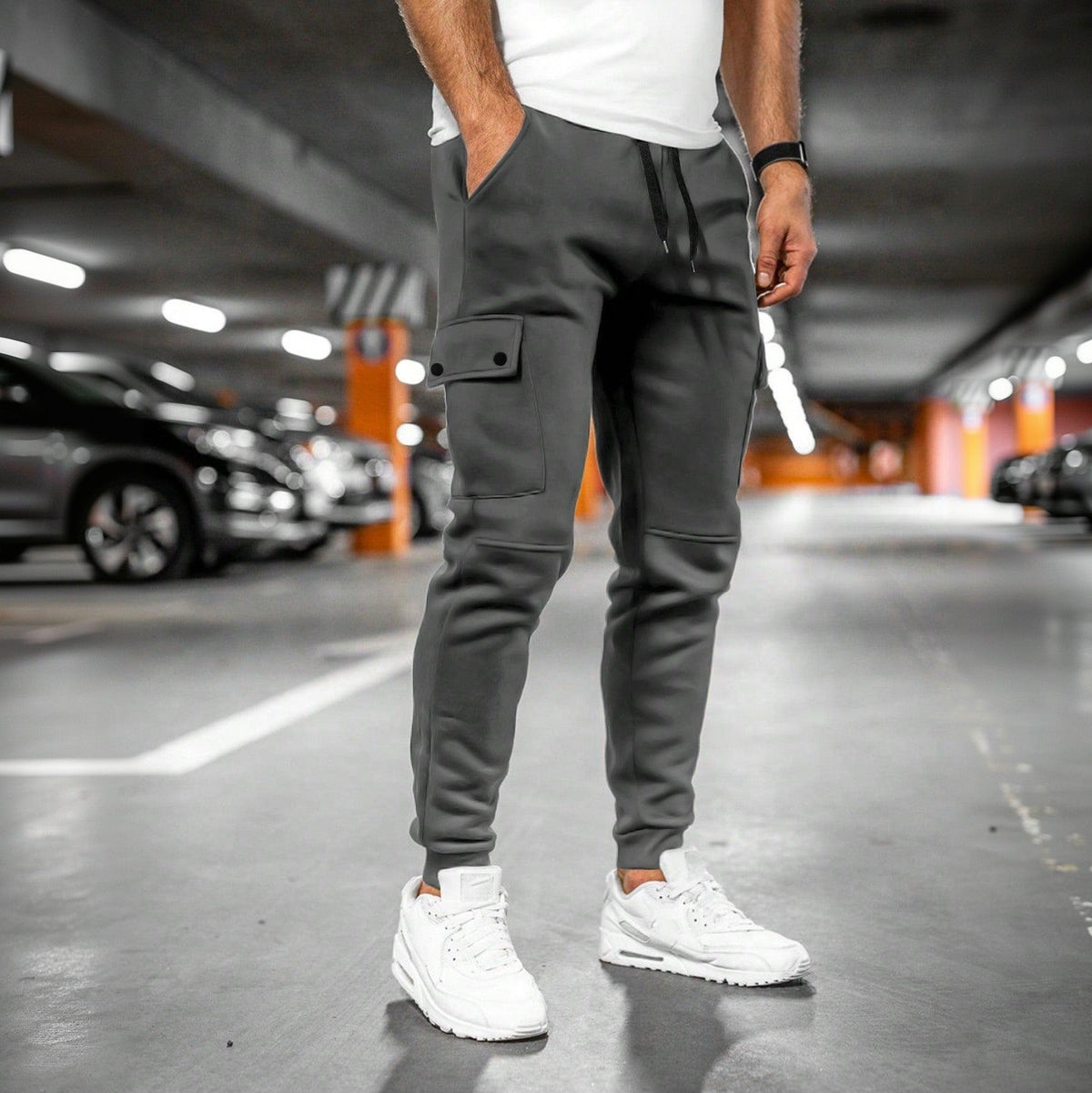 Grijze joggingbroek met cargozak, gedragen door man in parkeergarage | Boutique Moda