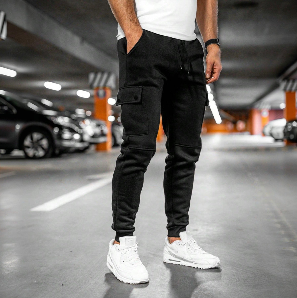 Man draagt zwarte joggingbroek met cargozak in parkeergarage | Boutique Moda