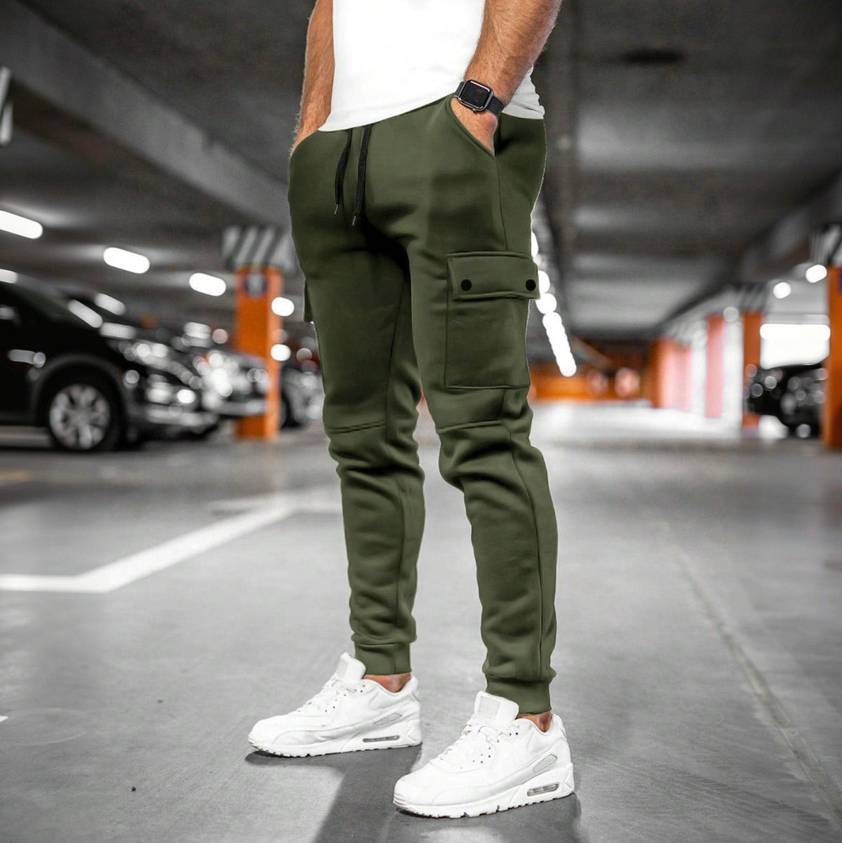 Groene joggingbroek met cargozak, gedragen door man in parkeergarage | Boutique Moda