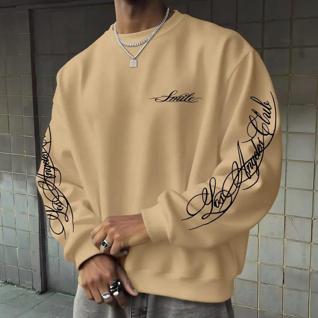 Beige sweater met letterprint op mouwen, ronde hals, gedragen door man | Boutique Moda