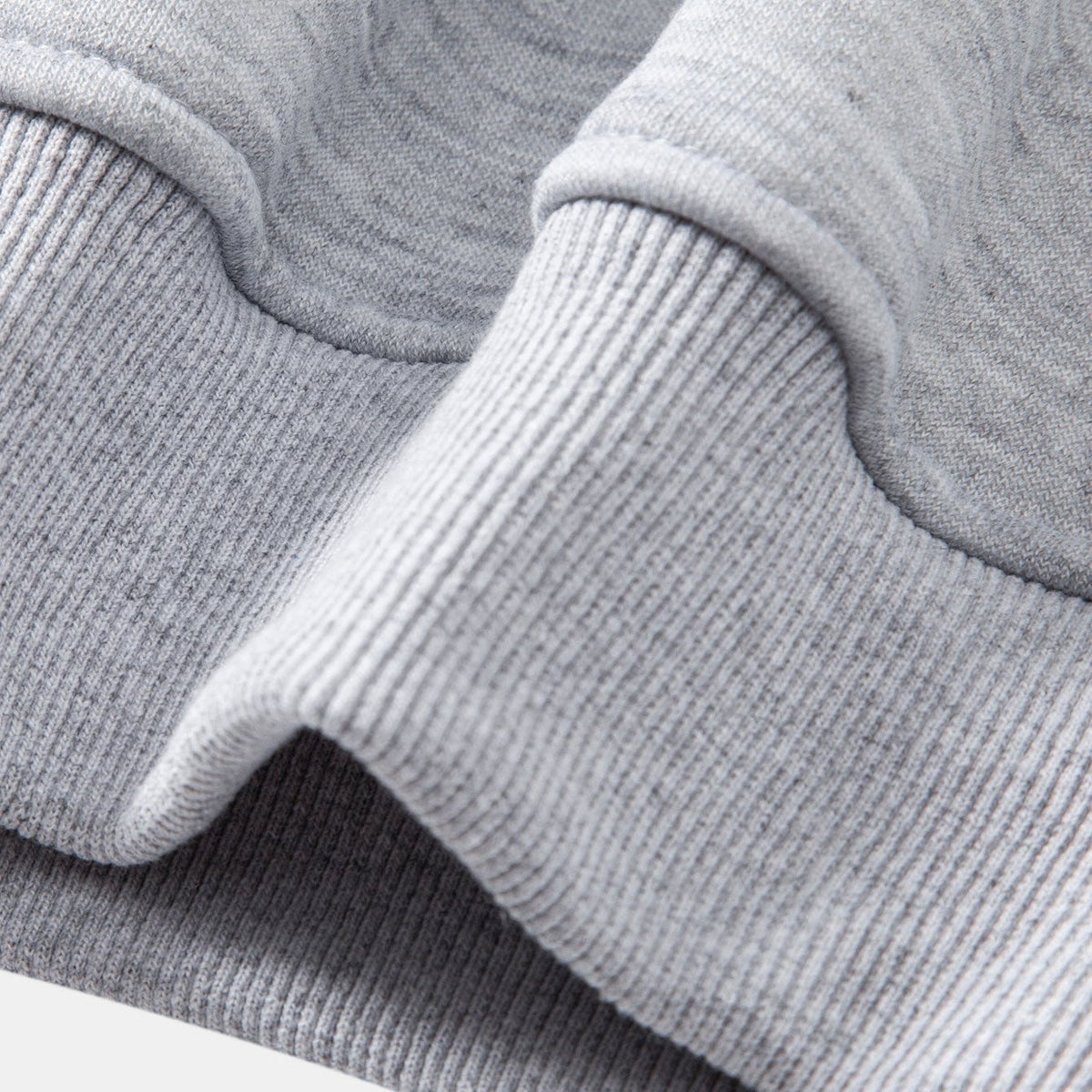 Close-up van grijze geribbelde boord aan mouw van sweater | Boutique Moda