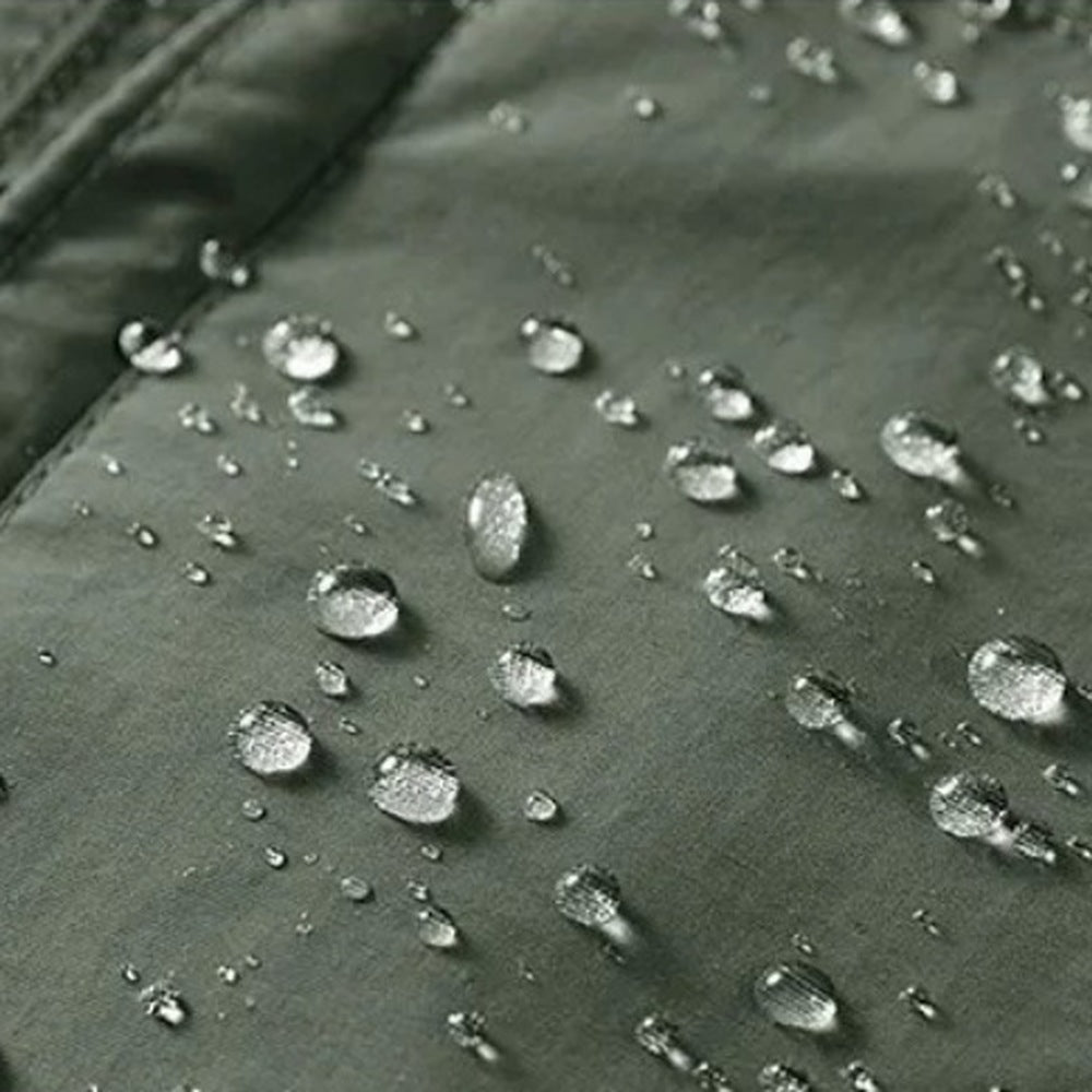 Waterdruppels op waterdichte groene stof, close-up detailweergave zonder persoon | Boutique Moda