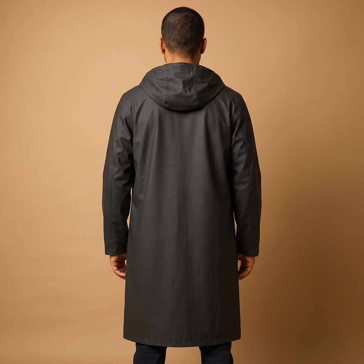 Lange zwarte regenjas met capuchon, gedragen door model, achteraanzicht | Boutique Moda