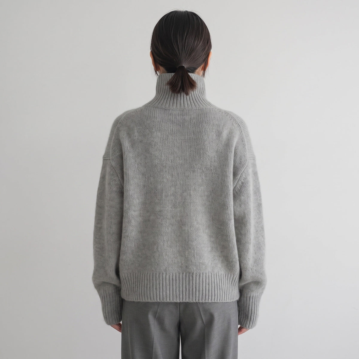 Grijze oversized coltrui, gedragen door vrouw, gezien van achteren | Boutique Moda