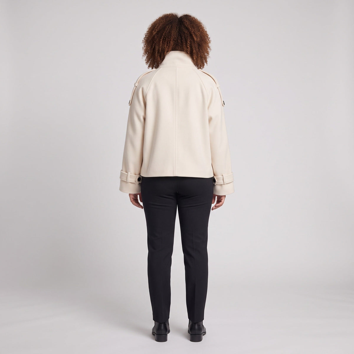 Beige korte jas met zwarte broek, gedragen door vrouw, achteraanzicht | Boutique Moda