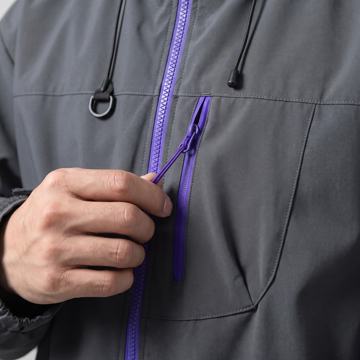 Grijze regenjas met paarse rits, gedragen, close-up van zakdetail | Boutique Moda