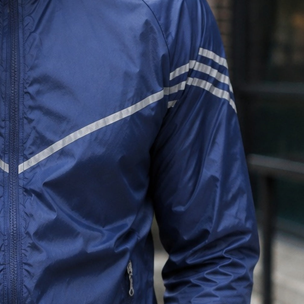 Donkerblauwe hardloopjas met reflecterende strepen, gedragen door een persoon, close-up | Boutique Moda