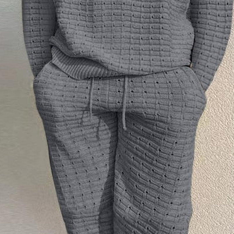Grijze gebreide loungeset met broek, gedragen door een persoon, close-up | Boutique Moda