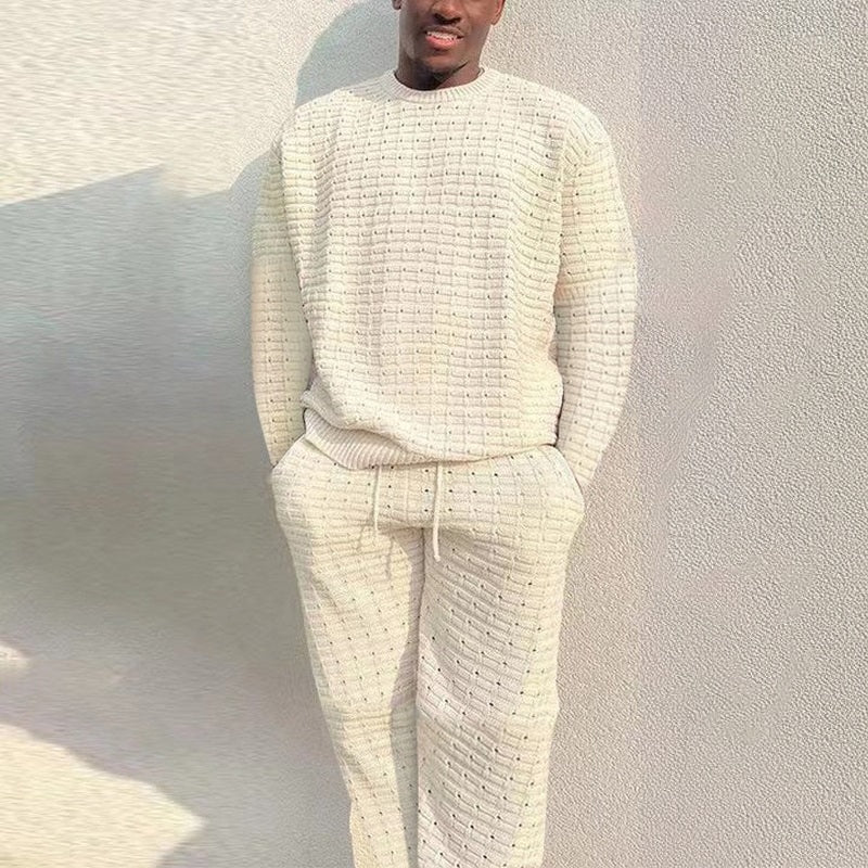 Man draagt gebreide crèmekleurige loungeset met trui en broek, gestructureerd patroon | Boutique Moda