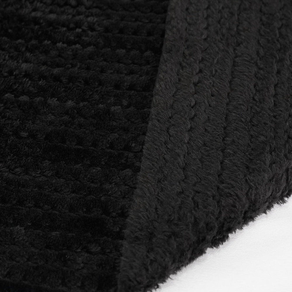 Close-up van zwarte stof met geribbelde en zachte structuur, plat uitgespreid | Boutique Moda