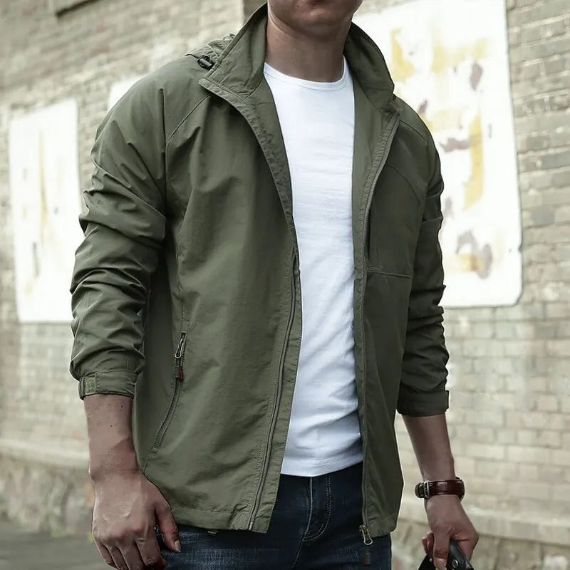Groene jas met capuchon en rits, gedragen door man buiten | Boutique Moda