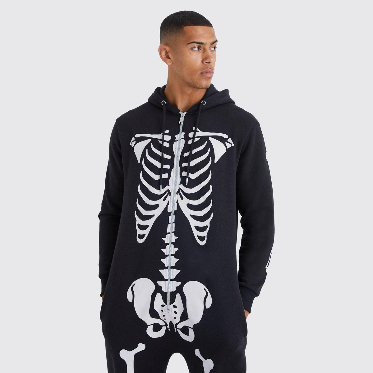 Zwarte onesie met capuchon en skeletprint, gedragen door man | Boutique Moda
