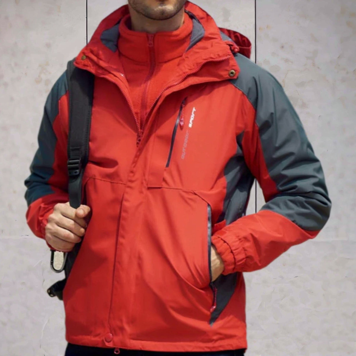 Rode wandeljas met grijze accenten, gedragen door man met rugzak | Boutique Moda