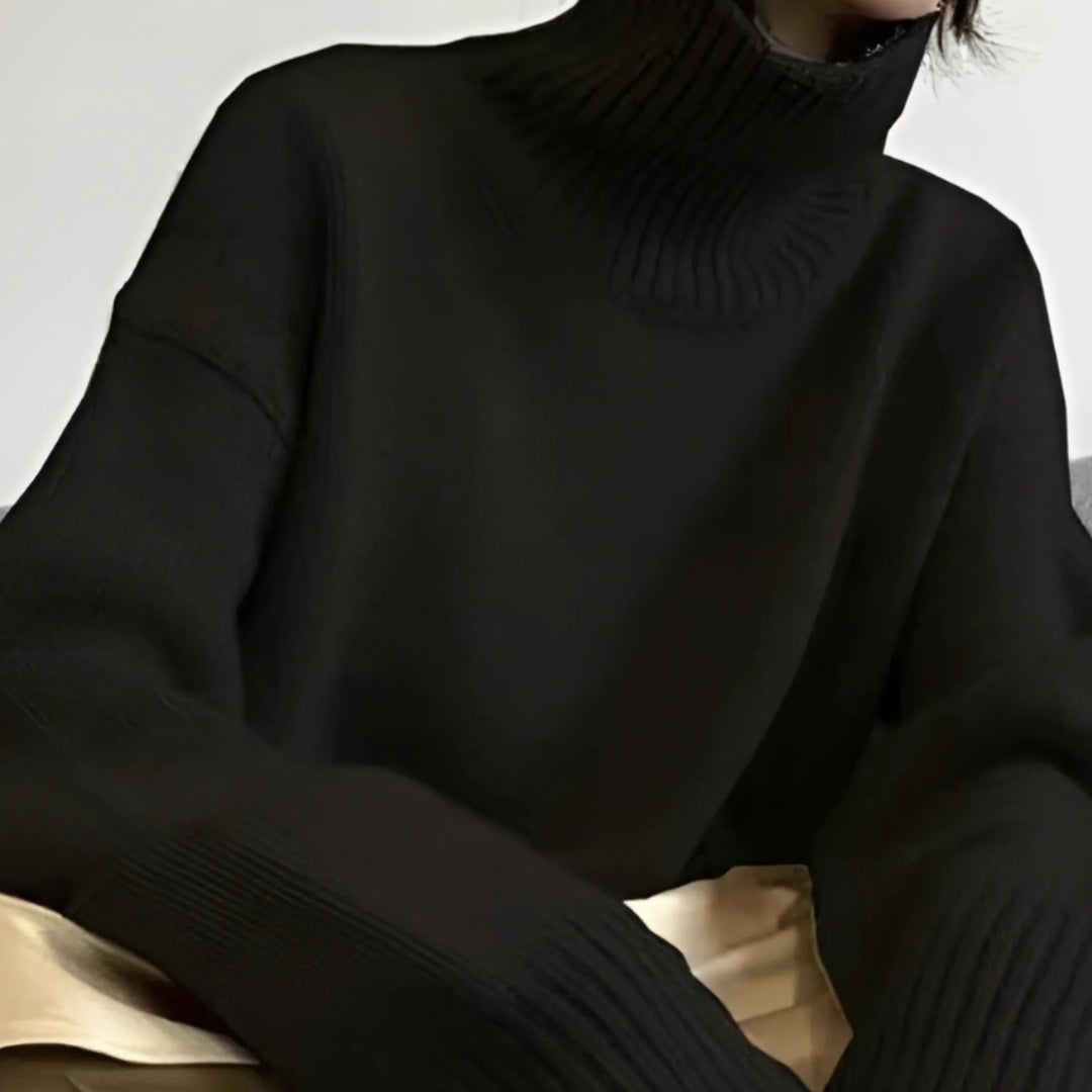 Zwarte oversized coltrui met geribde details, gedragen door een persoon, close-up | Boutique Moda