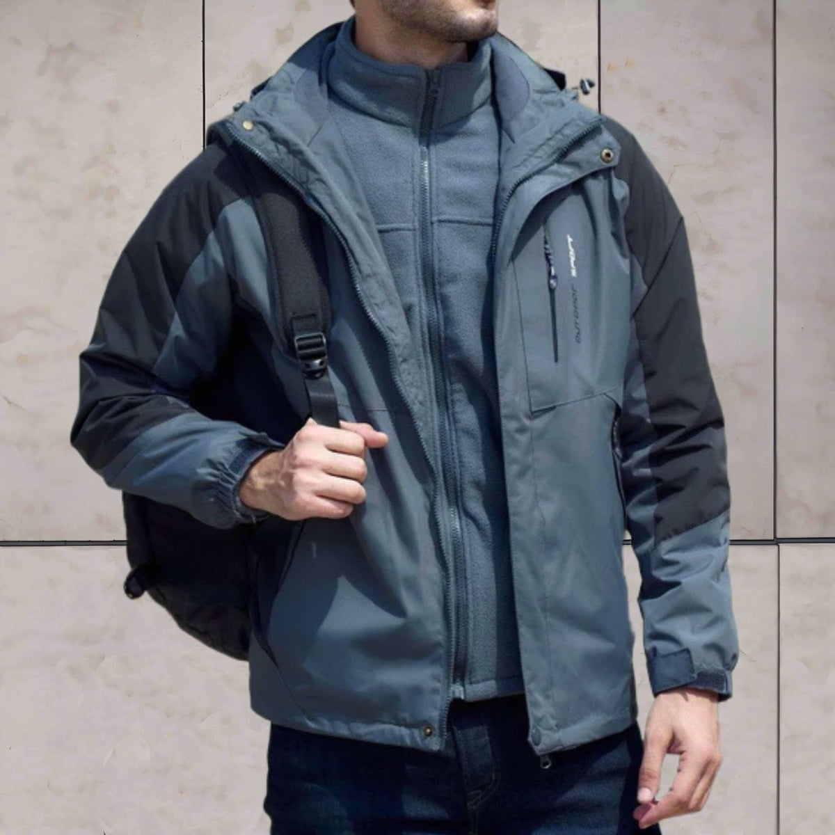 Grijze 3-in-1 wandeljas met capuchon, gedragen door man met rugzak | Boutique Moda