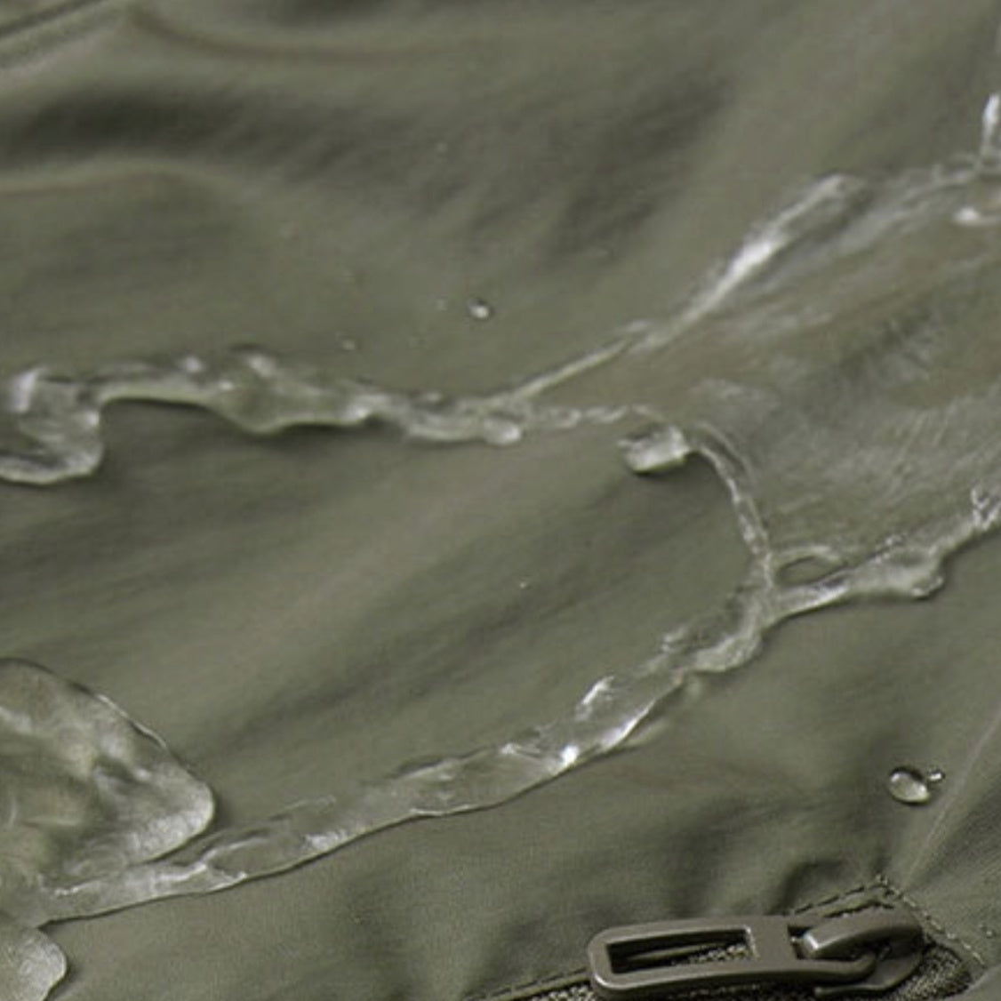 Groen waterafstotend jasje met waterdruppels en rits, close-up stof | Boutique Moda