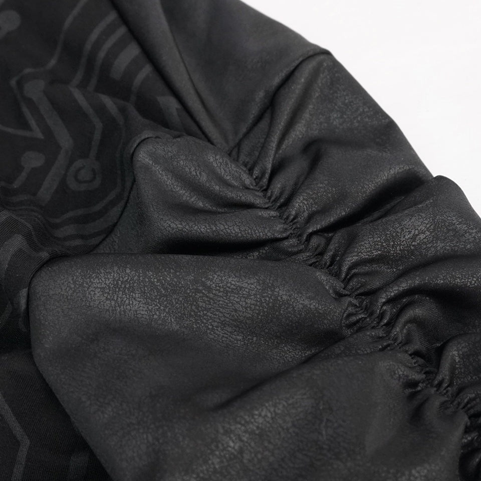 Close-up zwarte stof met elastieken rimpeling en subtiel print patroon zichtbaar | Boutique Moda
