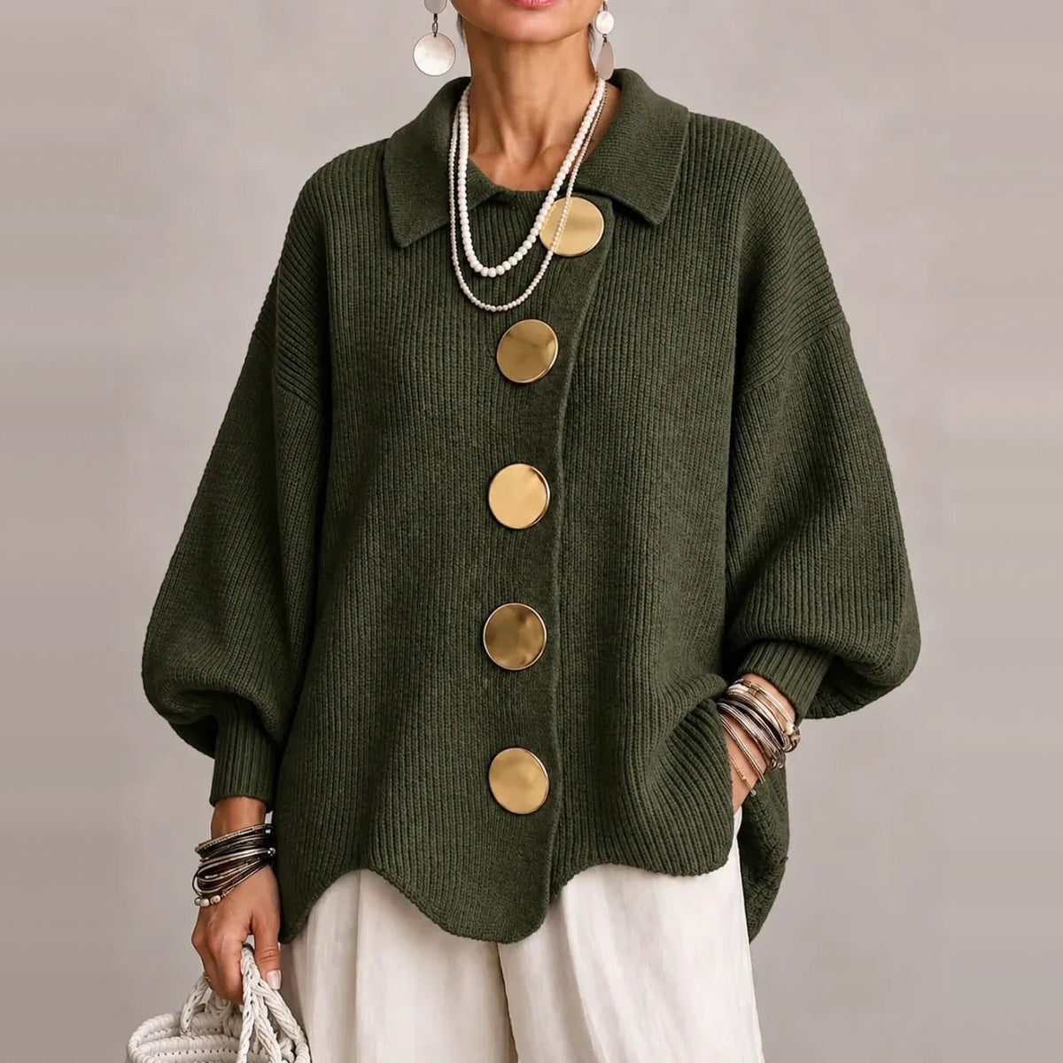 Groen gebreid vest met gouden knopen, gedragen door vrouw, golvende zoom zichtbaar | Boutique Moda
