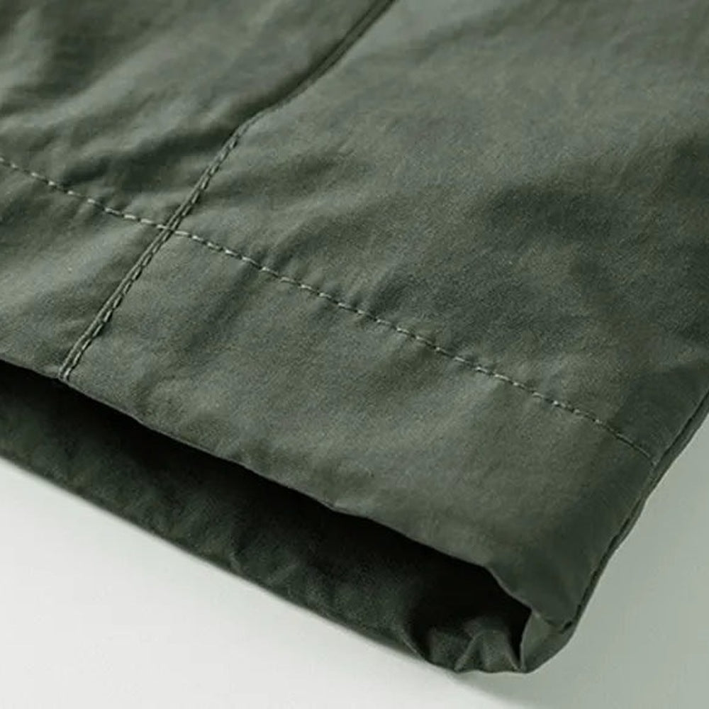 Close-up van kaki groene jas met stiksel en gevouwen stof detail | Boutique Moda