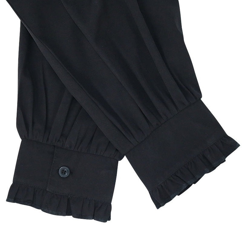 Zwarte blouse met geplooide manchetten en knoopsluiting, close-up detail | Boutique Moda